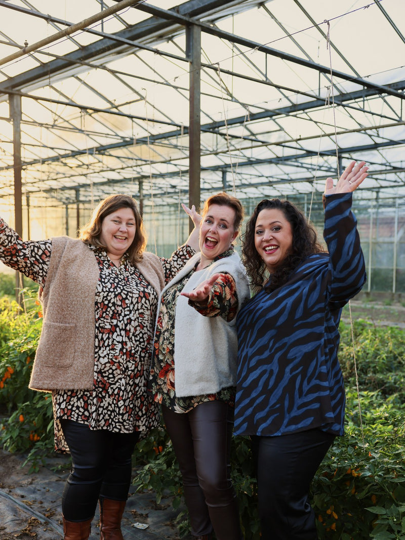 Drie dames zwaaiend in de kas